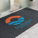 A large rectangular customizable entrance mat with a logo and text, designed for indoor or outdoor use.