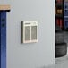 A Boltic steel electric fan-forced wall heater mounted on a light gray wall.