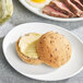 A plate of food with a dinner roll and a sandwich.