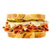 A sandwich with Prime Roots vegan smoked ham, cheese, and pickles.