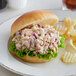 A sandwich on a plate with chips.
