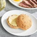 A plate of food with a dinner roll and a sandwich.