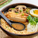 A bowl of Nippon Shokken miso ramen soup with meat, mushrooms, and eggs.