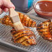 A person brushing Duke's Sweet BBQ Sauce on chicken breasts.