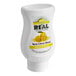 A white plastic container with a yellow label for Real Yuzu Puree Infused Syrup with a close up of a lemon.