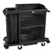 A Rubbermaid compact housekeeping cart with black bags on it.