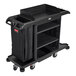 A black Rubbermaid® housekeeping cart with a bag on it.