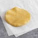 A Celia's yellow corn tortilla on a white paper.