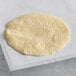 A round white ALTA Foods white corn tortilla with a textured surface.