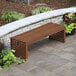 An Outdoor Interiors eucalyptus bench on a stone patio.