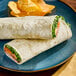 Two Celia's Rosemary herb garlic tortilla wraps on a plate with chips.