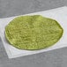 A green ALTA Foods spinach flour tortilla on a white surface.