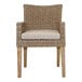 An Outdoor Interiors wicker arm chair with a white cushion.