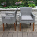Two brown Umber and gray wicker Outdoor Interiors dining arm chairs on a patio.