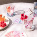 A table with Duralex Picardie blush glasses filled with drinks and a deck of cards.