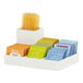 A white Cal-Mil condiment organizer with orange, green, and yellow packets inside.