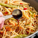 Golden Mountain Green Cap Seasoning Sauce being poured onto a bowl of noodles.