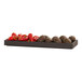 A black Brooklyn tray of vegetables on a table.