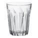 A clear glass tumbler with a curved design.