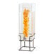 A Cal-Mil square glass beverage dispenser with oranges inside on a black wire base.
