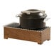 A black pot on a wooden stand.