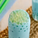 A glass of blue liquid with Fanale lychee popping boba in it.