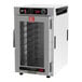 A white Metro heated holding cabinet with a clear door and black knobs holding trays.