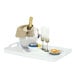A plastic room service tray with a champagne bottle and glasses on a table.