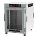 A white Metro heated holding cabinet with a clear glass door holding trays.
