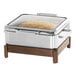 A stainless steel chafer with food in a container on a table.