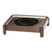 A stainless steel chafer with a black wood stand and a black circular warmer on a wood table.