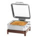 A stainless steel Winco chafing dish with food on a metal tray.