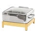 A stainless steel chafing dish with a wooden and silver stand and a clear glass lid.