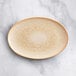 An Acopa beige porcelain oval platter on a marble surface.
