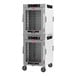 A white Metro heated holding cabinet with clear glass doors on wheels.