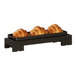 A Cal-Mil rectangular black wood display riser with three croissants on it.