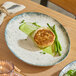 An oval gray porcelain platter with a speckled design, shown holding a plated meal.