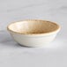 A white ramekin with brown specks.