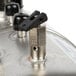 A close-up of a black metal valve with a hole.
