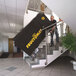 A powered stair climber being used to transport a large item labeled 'FRUCTOMAT' up a staircase.