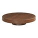 A Cal-Mil round walnut melamine cake pedestal on a wood table.