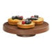 A Cal-Mil round walnut melamine cake pedestal displaying a fruit tart, fruit pie, and pastry.