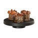 A group of brown cakes on a black Cal-Mil cake pedestal.