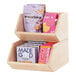 A blonde wood merchandiser with two shelves of snacks.