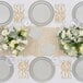 A table set with Sophistiplate Simply Eco Concrete Plant Fiber salad plates and silverware.