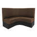 A brown and black curved corner booth with a table.