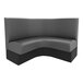 A QA Group curved corner booth with black and grey upholstery.