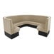 A tan and black curved sectional booth with a table.