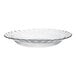 A clear glass plate with a scalloped edge.