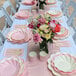 A table set with Sophistiplate Simply Eco Blush Plant Fiber Dinner Plates and flowers.